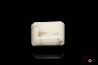 a white marble block on a black surface