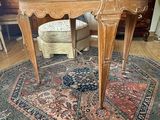 une petite table avec un plateau en marbre posée sur un tapis