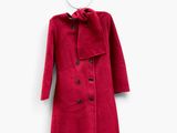 the red coat is hanging on a hanger on a white wall