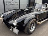 an image of a black sports car parked in front of a building