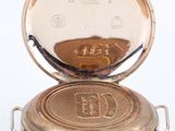 pocket watch on a white surface with a white background