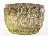 a stone planter that has moss growing on it