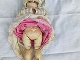 a doll that is laying down on a white sheet