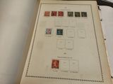 an old book with stamps on it sitting on a table