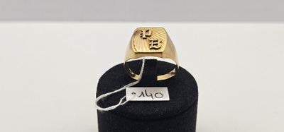 un gros plan d'une bague en or posée sur un présentoir noir