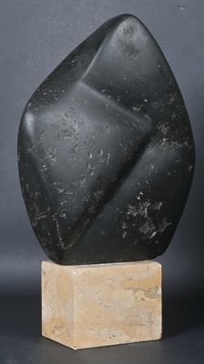 a black stone sculpture sitting on top of a wooden base