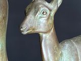 statue of a deer and a duck sitting on a wooden surface