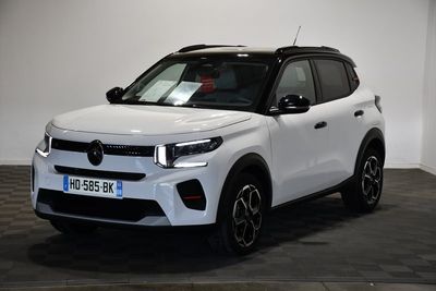 Un SUV blanc est garé dans une pièce dont le sol est en damier.