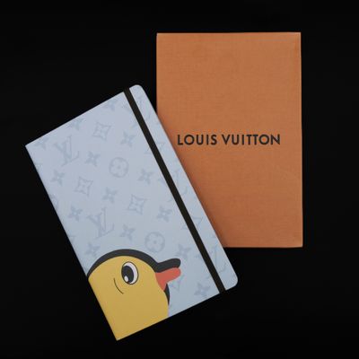 a louis vuitton notebook with a yellow bird on it