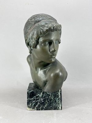 statue d'un jeune garçon dont la tête repose sur un bloc de marbre