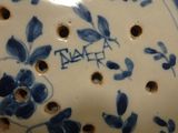 a close up of a blue and white plate with holes in it
