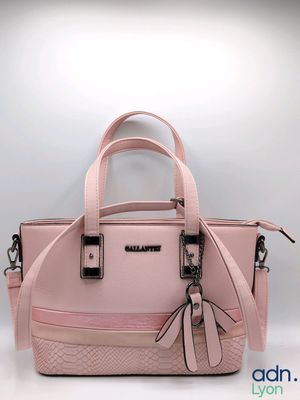 un sac à main rose orné d'un nœud sur la poignée