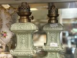 two green vases sitting on a glass shelf in a store