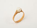 a close up of a gold ring with a pearl in it