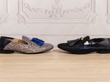 a pair of shoes with tassels on them sitting on a wooden floor