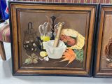 two framed pictures of food and vegetables on the table