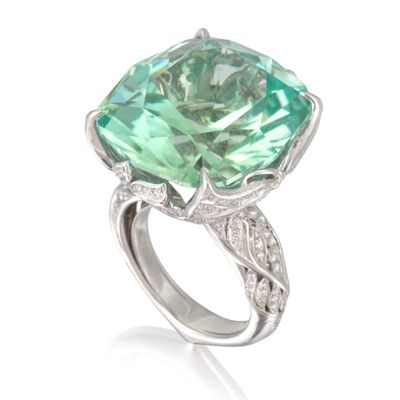 une image représentant une bague ornée d'une grosse pierre verte entourée de diamants