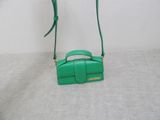 the small green bag is sitting on a white surface