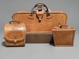 three pieces of luggage sitting next to each other on a gray surface