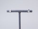 an image of a pair of diamond stud earrings sitting on top of a stand
