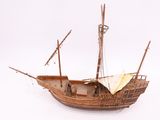 a model of a wooden boat on a white surface