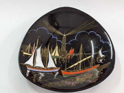 a black plate with a picture of a boat on it