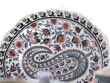 a close up of a plate with a paisley design on it