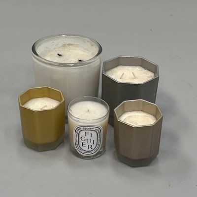Plusieurs bougies sont disposées en rangée sur une surface grise
