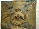 an old flag with a bird on it hanging on a wall