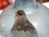 a blue vase with a hole in it on a table
