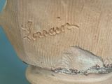 a vase that has a bird on it on a pedestal