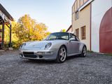 une voiture de sport argentée garée devant un immeuble