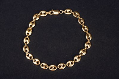 un bracelet plaqué or composé de maillons ovales sur fond noir
