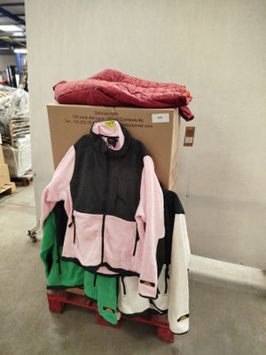 une pile de vêtements posée sur un chariot dans un entrepôt