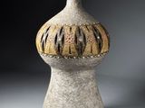 a white vase with a brown and black design on it