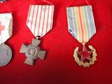 three medals and a medal laying on a red cloth