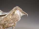 a silver bowl with a bird on top of it