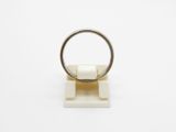 a close up of a ring on a stand on a white surface