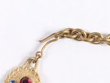 a gold bracelet with a red and blue stone on it