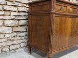 an old wooden chest of drawers in front of a stone wall