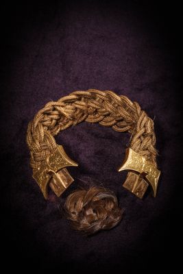 a close up of a gold bracelet on a black background