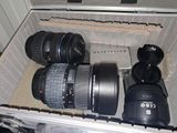 three camera lenses sitting in a case on the floor