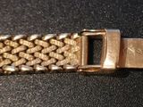 an image of a close up of a gold bracelet on a black surface