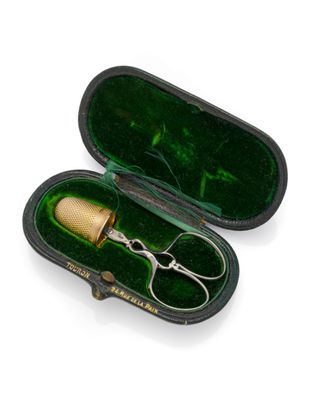 a pair of scissors in a case on a white surface