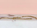 a close up of a gold chain bracelet on a marble surface