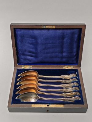 six spoons in a wooden box with a blue velvet lining