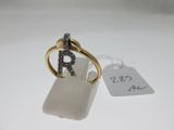 une photo d'une bague en or sertie d'une pierre blanche et d'un diamant noir