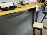 un comptoir jaune avec un tabouret devant