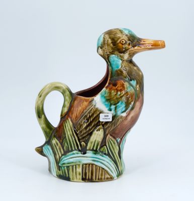 a ceramic duck that is sitting on a planter