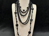 a black beaded necklace with black beads on a mannequin